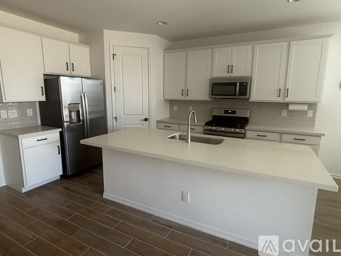 A kitchen with white cabinets and a large island.