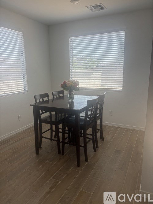 A dining room with a table and chairs.