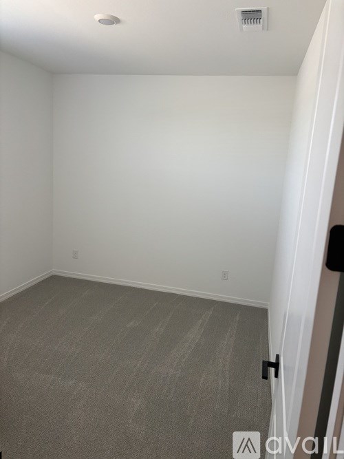A room with a carpeted floor and a white wall.