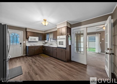 A kitchen with a refrigerator, microwave, and oven.