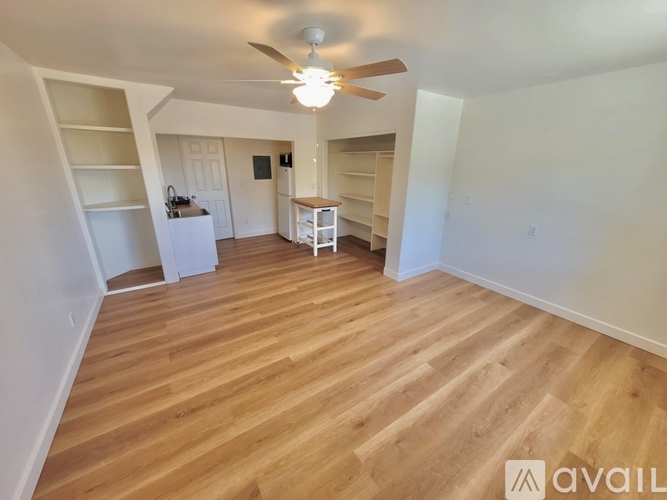 A room with wooden flooring and a ceiling fan.