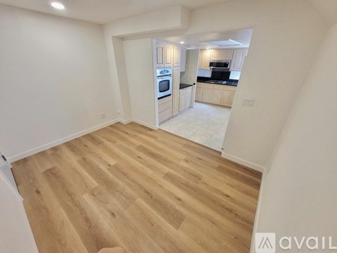 A room with a ceiling fan and wooden flooring.