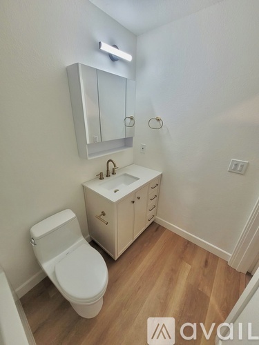 A white toilet sits next to a sink in a small bathroom.