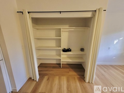 A kitchen with a white fridge and wooden floors.