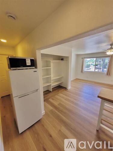 A kitchen area with a wooden table and chairs.