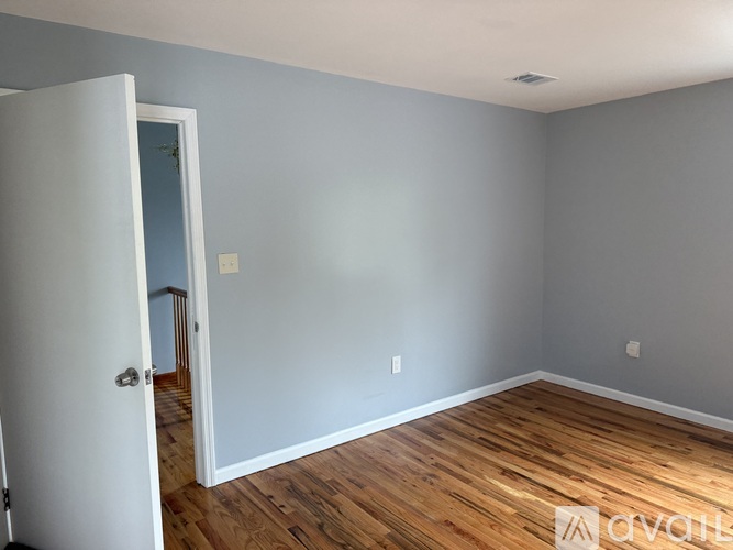 A room with a wooden floor and a white door.