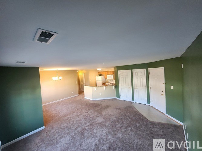 A kitchen with a white refrigerator, brown cabinets, and a granite countertop.