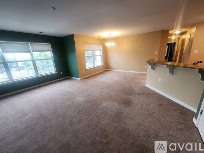 A spacious room with a carpeted floor and a large window.