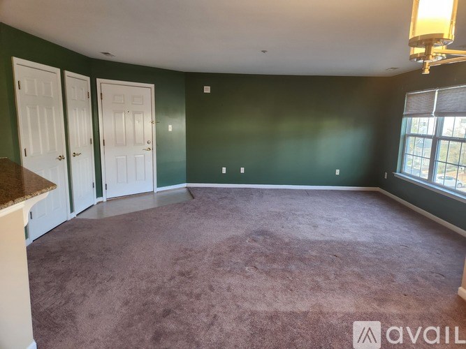 A room with a ceiling fan and two windows.