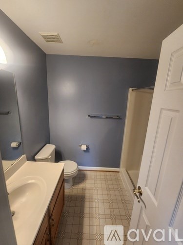 A bathroom with a toilet, sink, and mirror.