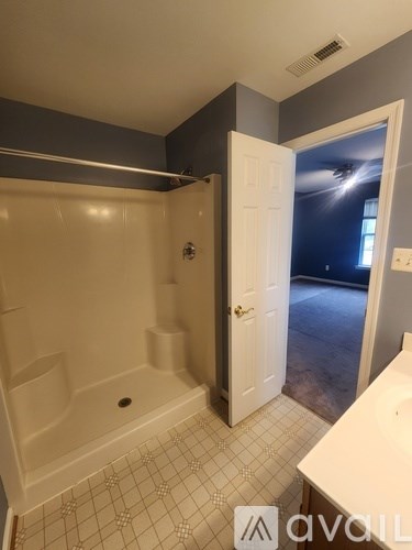 A bathroom with a white tub and tiled floor.