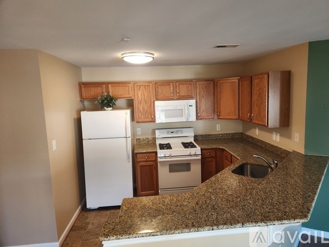 A kitchen with granite countertops and white appliances.
