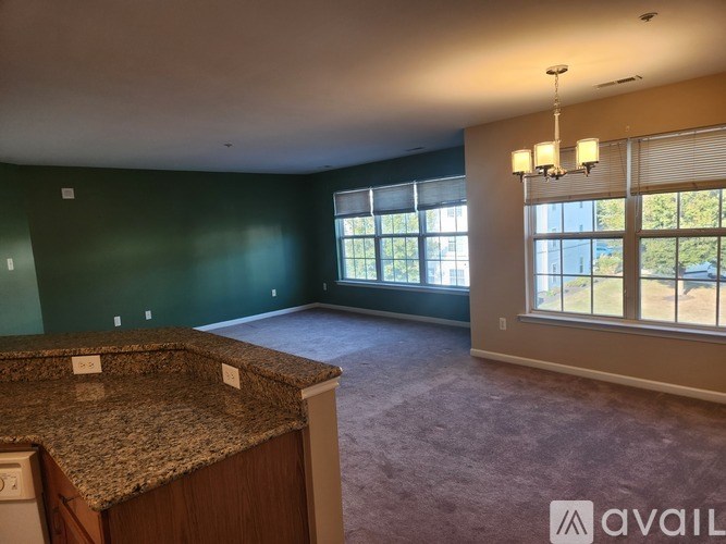 A room with a carpeted floor and a door on the right side.