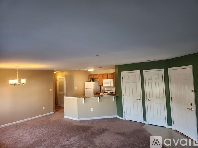 A room with a carpeted floor and a white counter in the middle.
