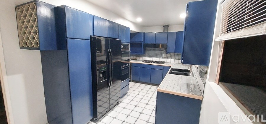 A kitchen with blue cabinets and appliances.