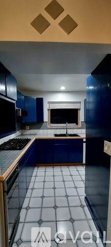 A kitchen with blue cabinets and a tiled floor.