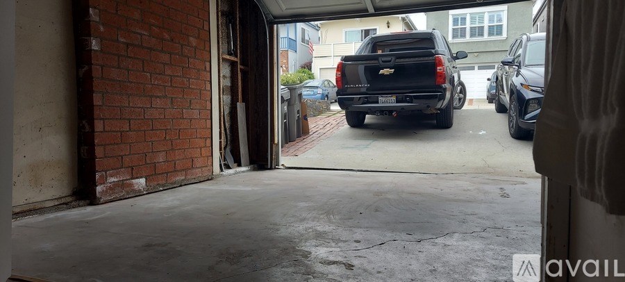 A black Chevy truck is parked in a driveway.