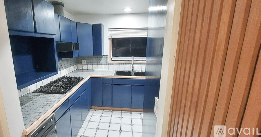 A kitchen with blue cabinets and a window.