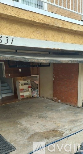 A garage with a red door and a white sign with the number 531.