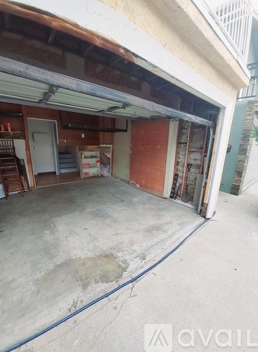 A garage with a blue hose on the floor.