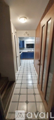 A hallway with a tiled floor and a door on the right.