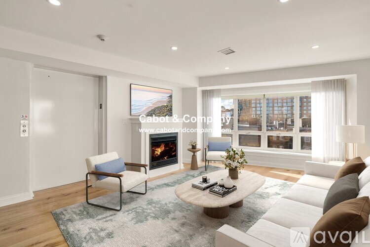 A modern living room with a fireplace and a painting of a beach scene on the wall.