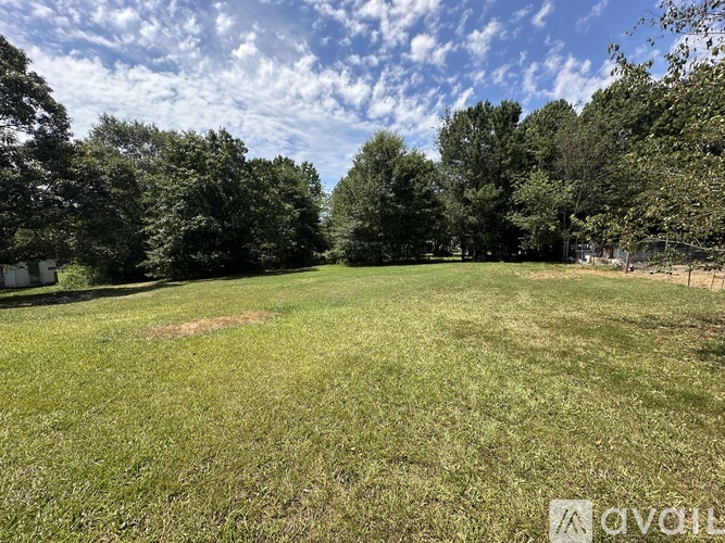 A grassy field with trees in the background.