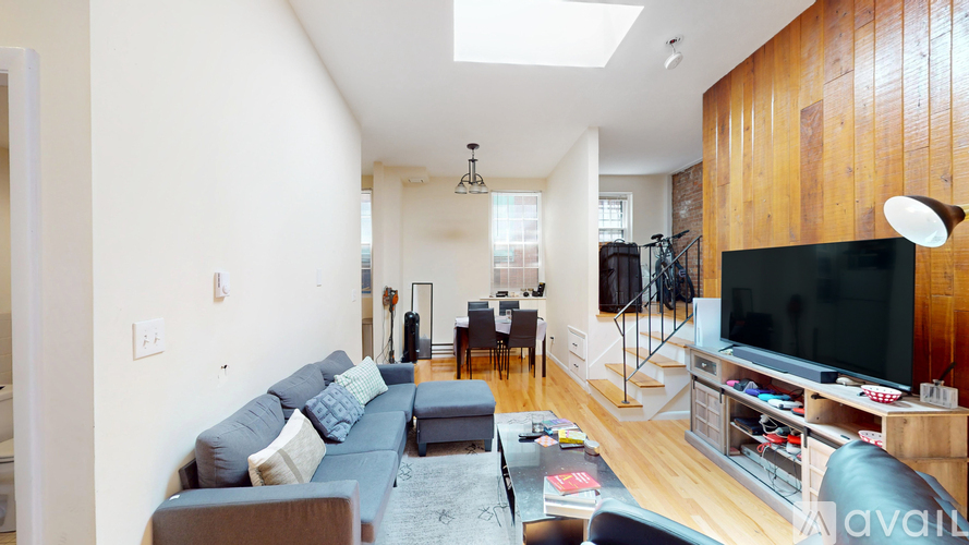 A living room with a grey couch and a black television.