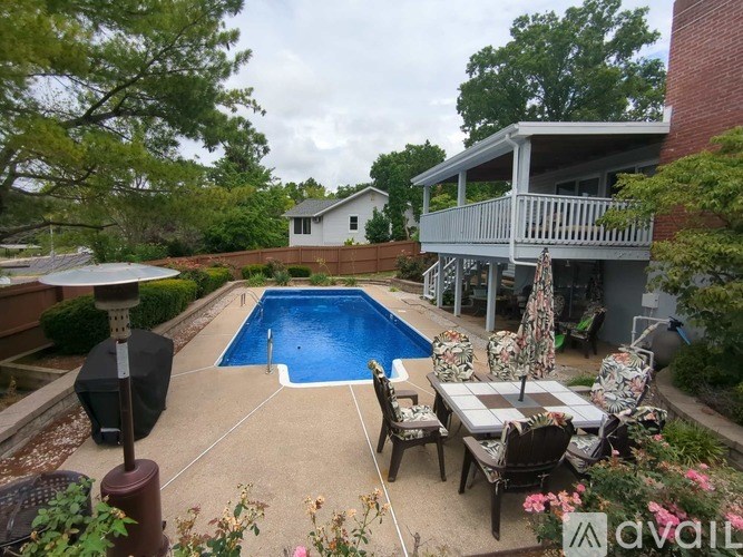 A backyard with a pool and patio furniture.