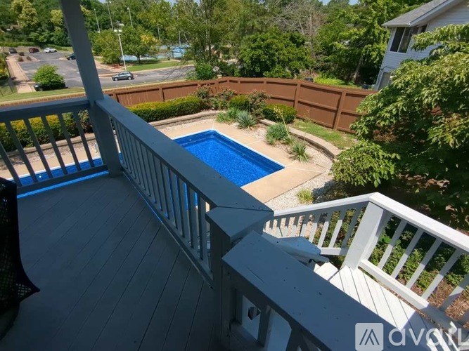 A deck with a pool and a fence.
