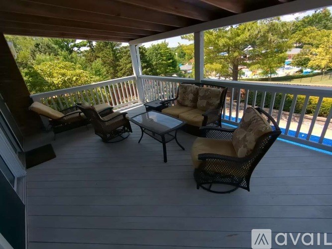 A wooden deck with chairs and a table.