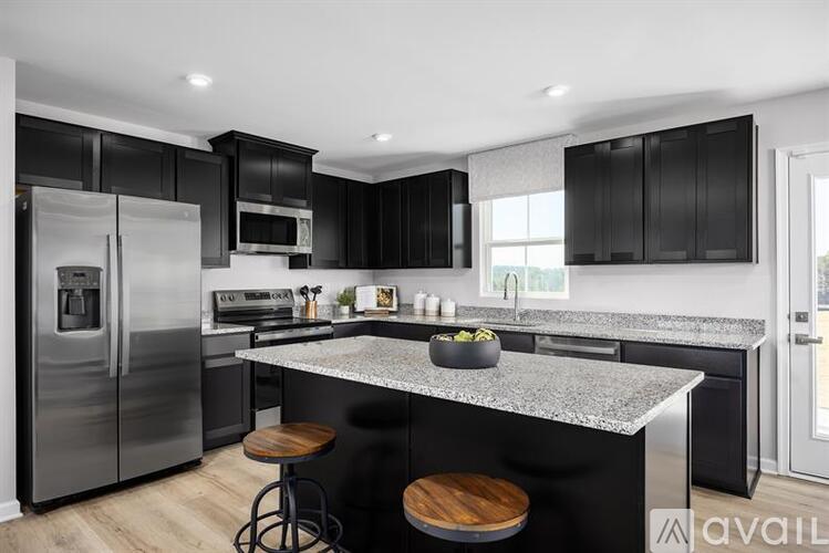 A modern kitchen with black cabinets and a granite countertop.