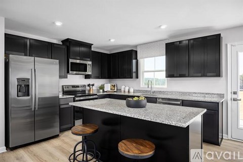 A modern kitchen with black cabinets and a granite countertop.