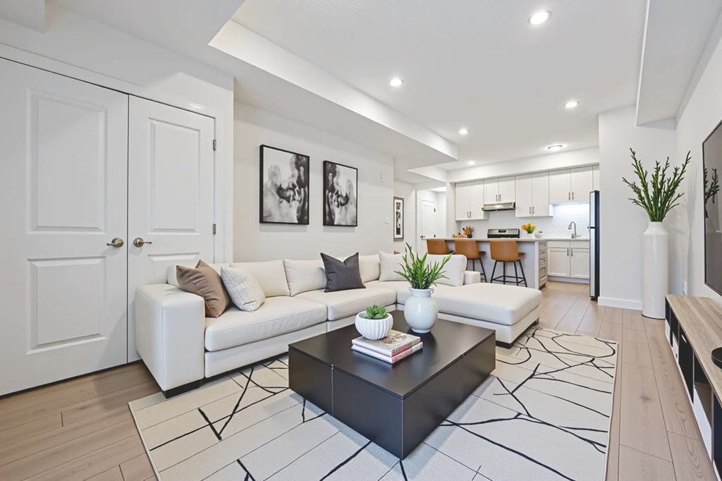 A modern living room with a white couch, a black coffee table, and a rug with a geometric pattern.