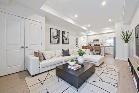 A modern living room with a white couch, a black coffee table, and a rug with a geometric pattern.