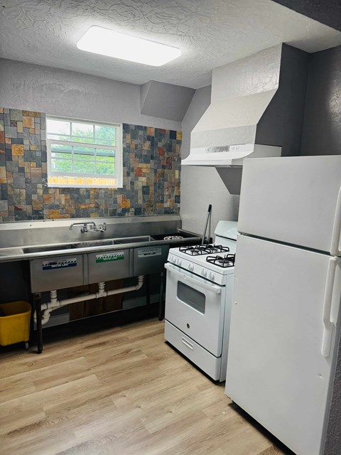 A kitchen with a white refrigerator and a white stove top oven.
