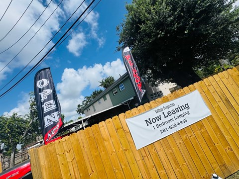 A sign for a bed and breakfast leasing service is displayed on a wooden fence.