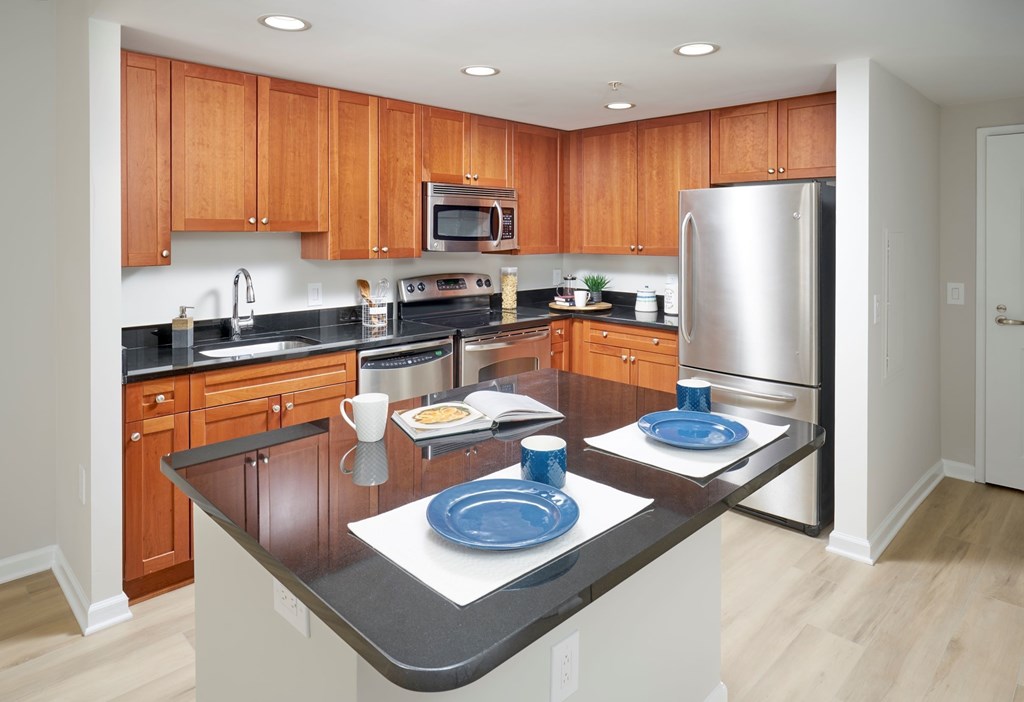 A kitchen with wooden cabinets and a black countertop.