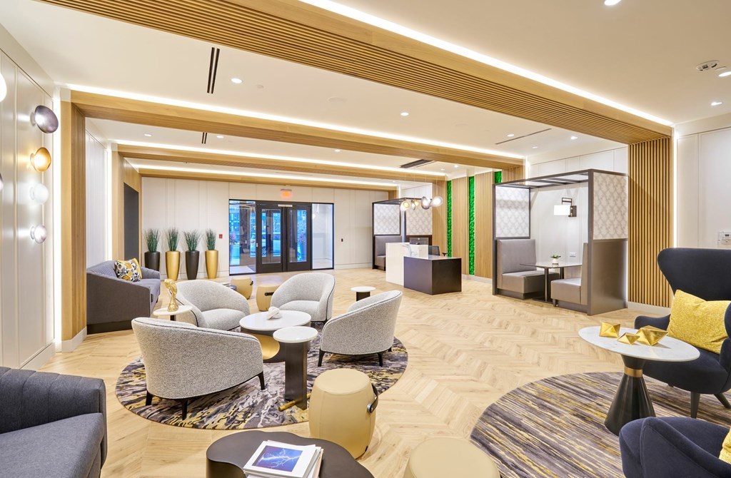 A modern living room with a variety of seating options and a large window.