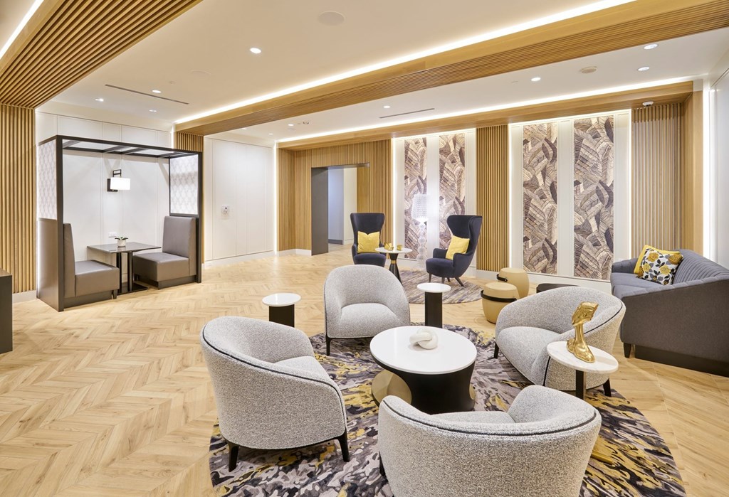 A living room with a variety of chairs and a patterned rug.