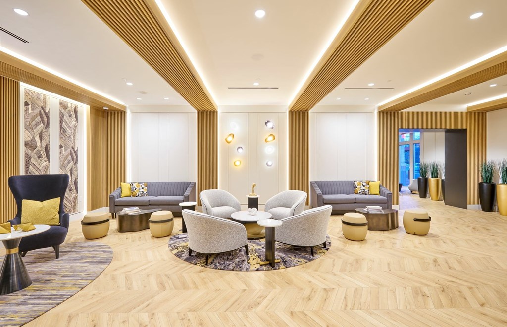 A spacious living room with a variety of seating options and a wooden floor.