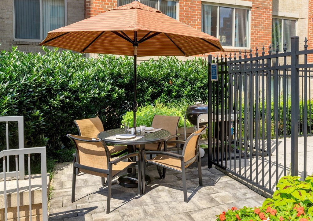 A patio with a table and chairs under an umbrella.