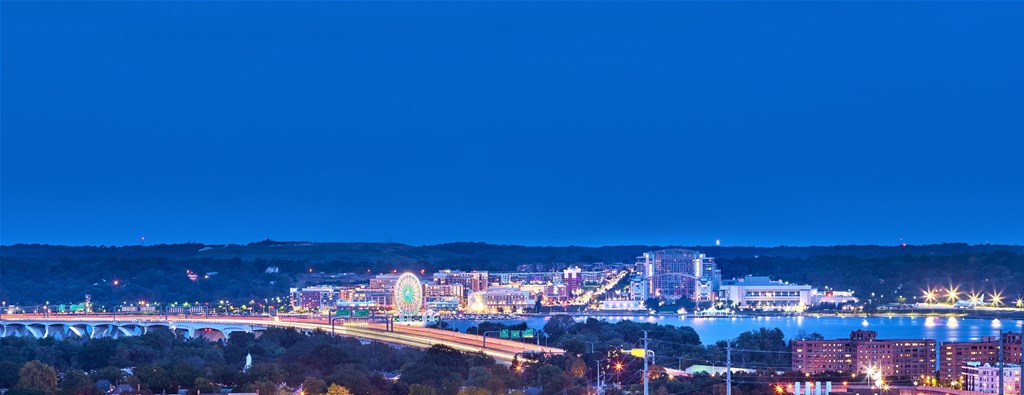 A cityscape at night with a bridge and buildings illuminated.