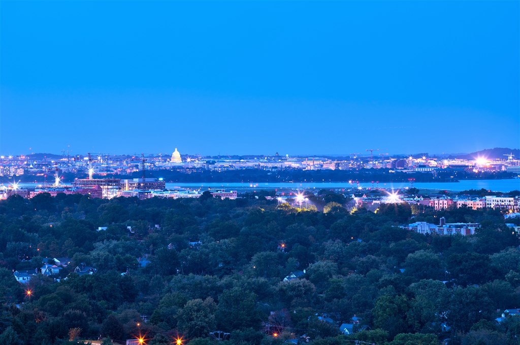 A cityscape at night with a lit-up building in the distance.