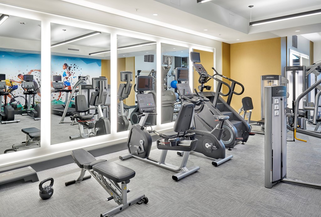 A large white building with a spire stands in a lush green field.