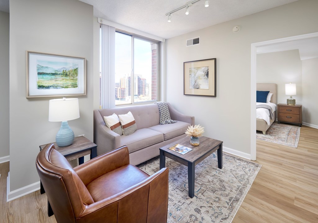 A living room with a brown leather chair and a grey couch.