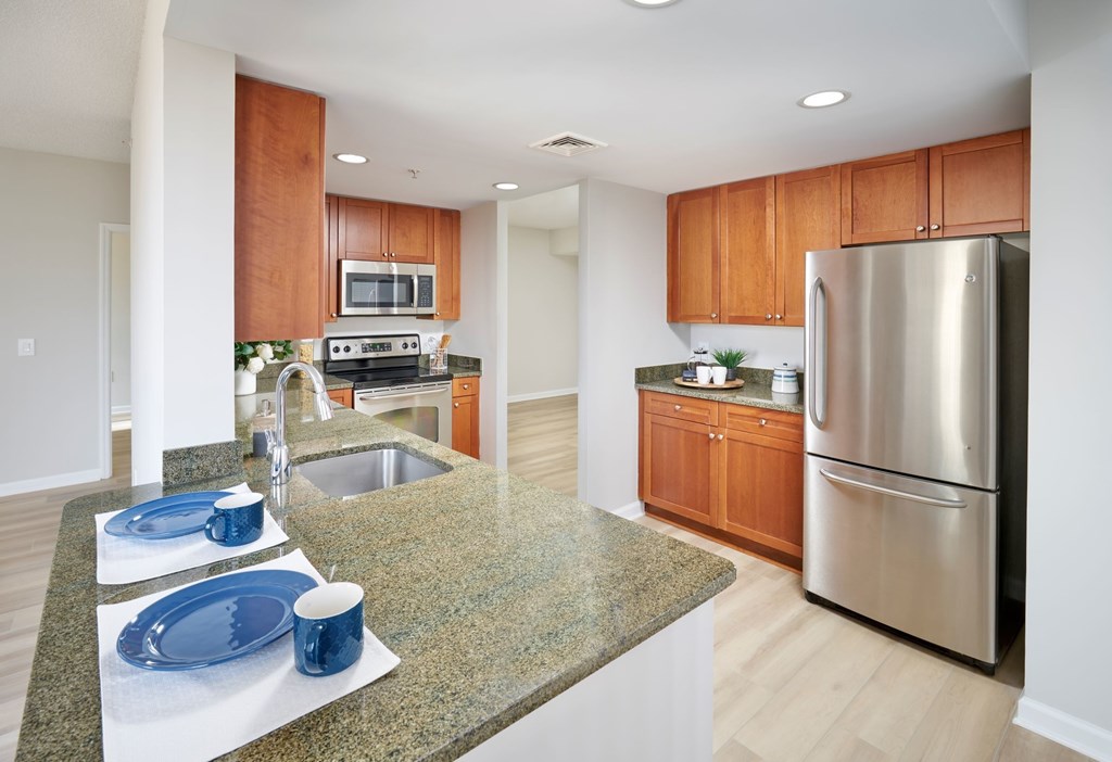 A kitchen with a granite countertop and stainless steel appliances.