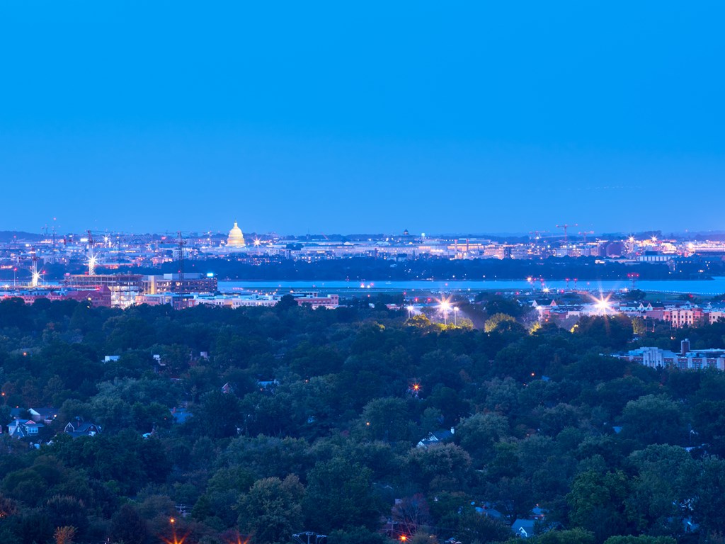 A cityscape at dusk with a prominent building in the distance.