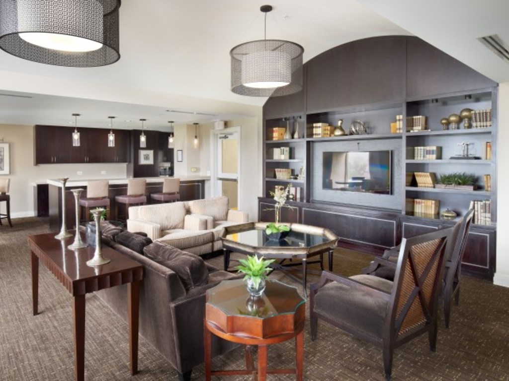 A modern living room with a dark brown sofa set and a glass coffee table.
