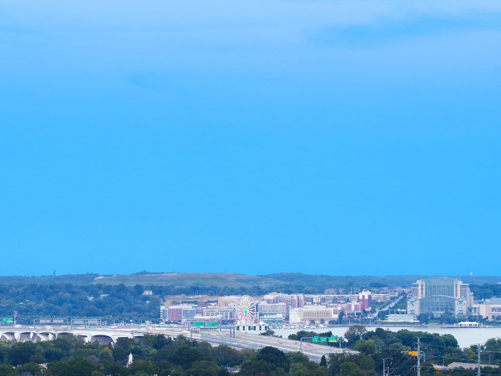 A cityscape with a bridge and buildings under a clear sky.
